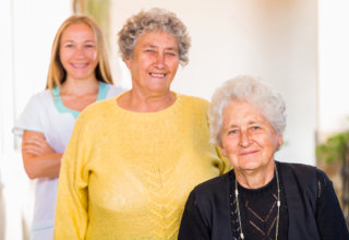 caregiver and old woman showing their genuine smile